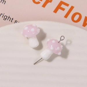 Detailed view of pink glass mushroom beads with white polka dots for DIY jewelry making
