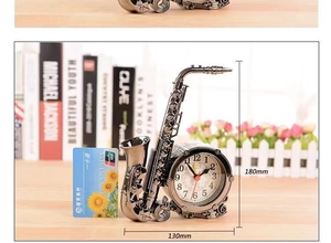 Macro view of saxophone-shaped creative alarm clock with size labels in silver finish