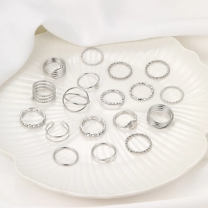 Macro shot of 21pcs silver metal ring set featuring twist, chain and hollow heart designs
