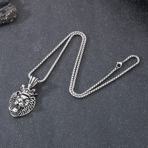 Pendentif tête de lion argent hip-hop avec couronne et chaîne sur fond texturé sombre