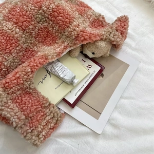 Detail of pink checkerboard plush tote bag with cozy teddy bear and lifestyle props