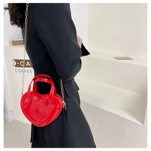 Close-up of a glossy red heart-shaped mini bag with elegant gold metal chain strap