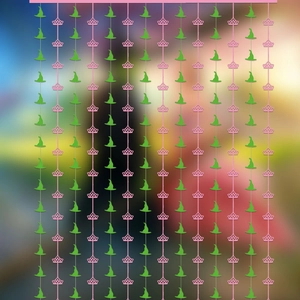 Close-up of green witch hats and pink crowns pattern on a festive foil fringe curtain