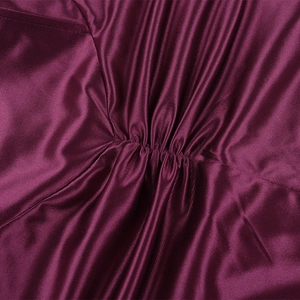 Gros plan sur la texture élégante du satin plissé bordeaux d'une robe de soirée formelle
