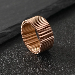 Modern rose gold mesh woven ring made of stainless steel on a dark stone background