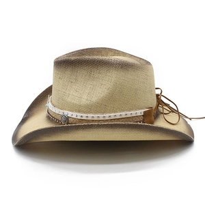 Close-up of vintage straw cowboy hat with burnt edges and metallic buckle band