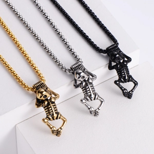Detailed view of three 304 stainless steel skeleton pendants in gold, silver, and black