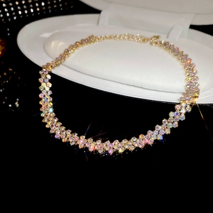 Close-up of golden wavy choker necklace featuring multi-colored sparkling rhinestones
