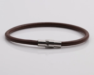 Dettaglio del bracciale in pelle marrone con chiusura magnetica in metallo argento