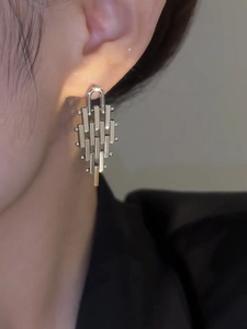 Detail of silver geometric fringe earrings with vertical bars and beads on a model