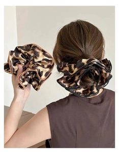 Close-up of double-layer leopard print hair scrunchies with glossy satin texture