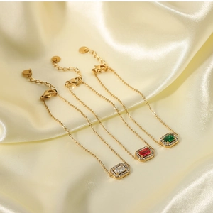 Macro detail of 18K gold-plated bracelets with colorful zircon stones on silk