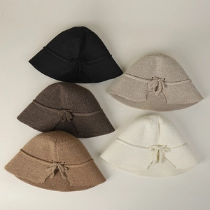 Detailed flat lay of knitted sun hats in five colors featuring bow-tie accents