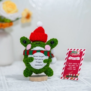 Handmade crochet frog in Christmas hat with emotional support card on wooden base