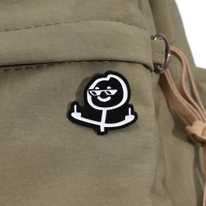 Lustiger Stickman Emaille-Pin mit Sonnenbrille und Mittelfinger auf grünem Rucksack