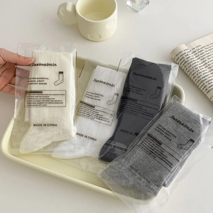 Japanese style mesh lace slouch socks in white, black and grey on a tray