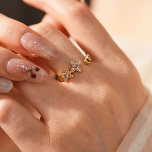 Close-up of golden vintage ring with purple stars and sparkling zircon flower details