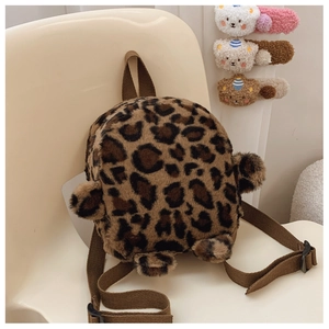 Detail of plush leopard print toddler backpack with soft ears on an off-white chair