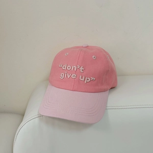 Detalle del bordado blanco en una gorra de béisbol rosa bicolor para mujer y hombre