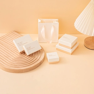 Elegant white jewelry gift boxes and paper bag set with gold trim and embossed logo