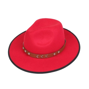 Detail view of red fedora hat with brown leather band and silver metal bull head ornament
