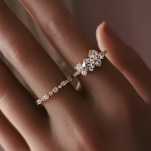 Primo piano di un set di anelli in argento dorato con pietre di zircone sulle dita