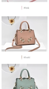 Close-up of floral embroidery on soft leather tote with heart-shaped metal rings