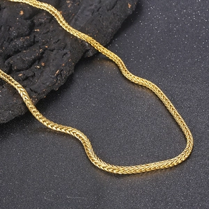 Glänzende goldfarbene Gliederkette im Drachenknochen-Design auf schwarzem Felsen