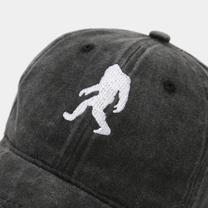 Close-up of vintage washed cotton baseball cap featuring white Bigfoot silhouette embroidery