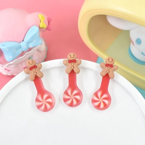 Close-up of resin Christmas gingerbread man spoons on a decorative white plate