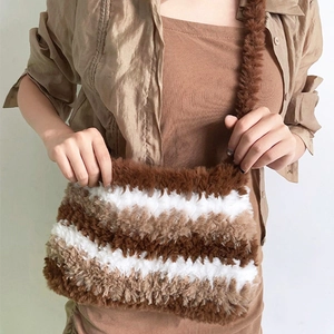 Detail of plush crossbody bag featuring brown and beige striped faux fur texture