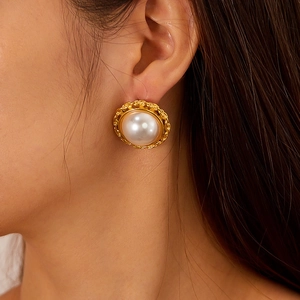 Detail of vintage French style pearl stud earring with golden braided texture on model