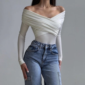 Detail showing the soft ribbed fabric and off-shoulder V-neck design of the white bodysuit