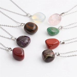 Flat lay of colorful irregular gemstone pendants with polished silver-tone metal chains