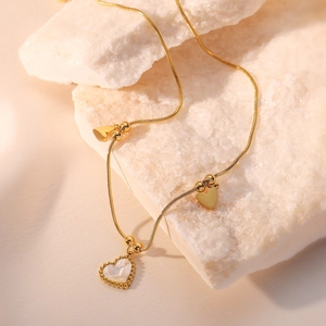 Gold plated stainless steel heart pendant necklace with shimmering shell inlay on a stone