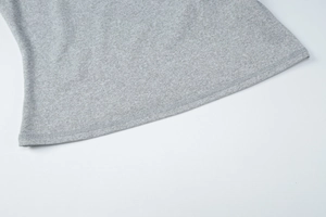 Close-up of gray knitted top hem showing professional double-needle stitching and fabric texture