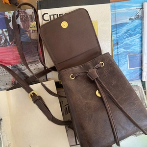 Dettaglio mini zaino in pelle marrone retrò con coulisse e chiusura magnetica