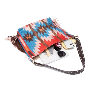 Top view of large woven tote bag with colorful patterns, brown tassels, and daily essentials