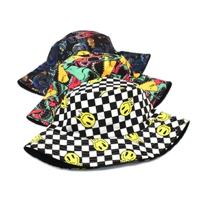 Détail de bobs réversibles avec damier à smiley et imprimés graffiti multicolores