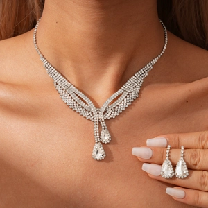 Close-up of sparkling teardrop pendant necklace and matching earrings on model