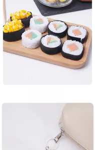 Realistic PVC sushi keychain set including corn and cucumber rolls on a beige bag