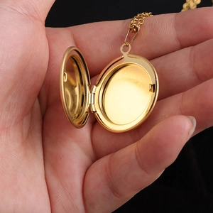 Detail view of a gold circular 316L stainless steel locket showing the inner compartment