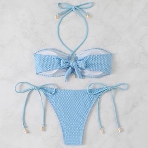 Detail of light blue textured bikini with halter ties and natural seashell accents