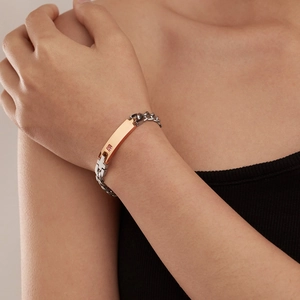 Close-up of rose gold and silver couple bracelet with pink stone on female wrist
