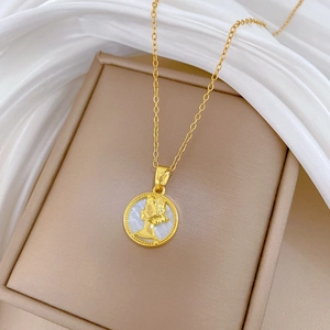Detailaufnahme der goldenen Muschel-Halskette mit Porträt-Münze in einer Schmuckschatulle