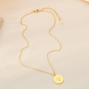 Détail du pendentif en acier titane doré avec gravure Good Fortune et petit strass