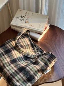 Détail de la texture en laine à carreaux et du fermoir magnétique argenté sur le sac cabas