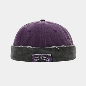 Detailed macro view of vintage washed canvas docker cap with purple embroidery patch