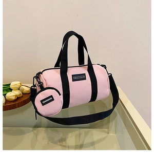 Detailed view of pink nylon Boston bag with detachable coin purse on glass table