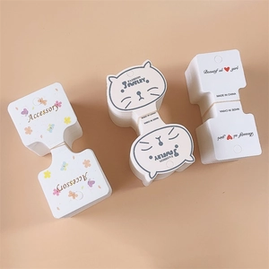 Various cute white jewelry display cards with floral, cat, and bone shapes for hair clips